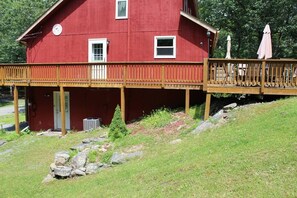 A red building with a wooden deck and a small covered area with outdoor seating. - FREE Amenity Passes Spacious Sauna Large Deck Firepit (Lehman township)