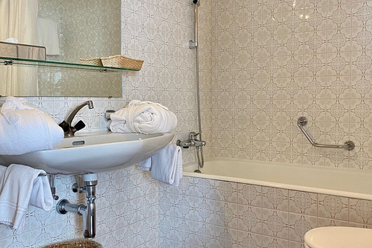 Un baño con lavamanos blanco, bañera e inodoro.