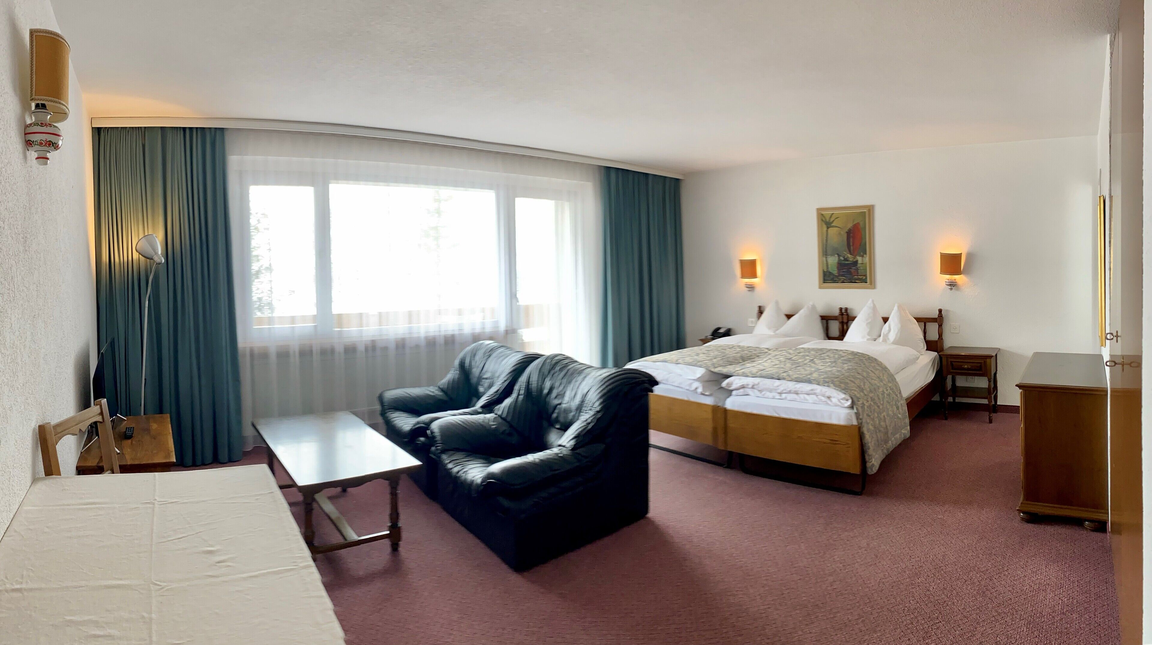 Une chambre d’hôtel avec un lit, un canapé, un bureau et une chaise.