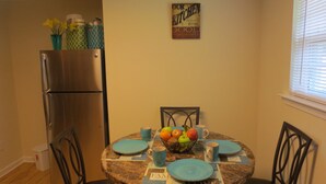 A dining area with a marble table, blue placemats, and a fruit bowl. - Apartment In Downtown Durham (Durham)