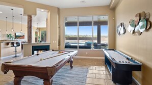 A pool table in a room with a large window, a bar area, and a fireplace. - Voted # 1 House-Pool, Pickleball, Golf, Basketball (Scottsdale)