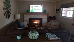 A living room with a fireplace, a television, and a sofa.