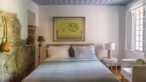 A bedroom with a bed, a lamp, a chair, and a painting on the wall. - Acropolis Villa (Athens)