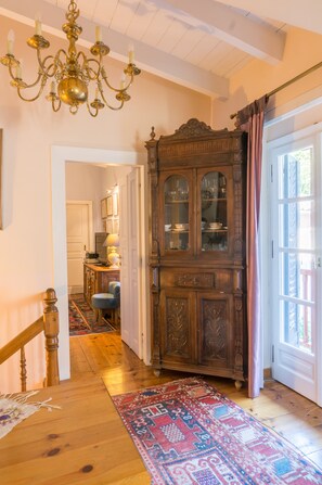 Stunning hallway leads to a dining area with a chandelier and ornate cabinet.