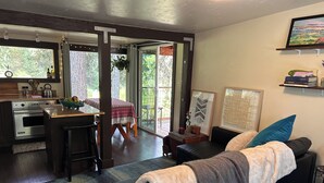 Una sala acogedora con un sofá, una mesa de comedor y una cocina equipada con horno.
