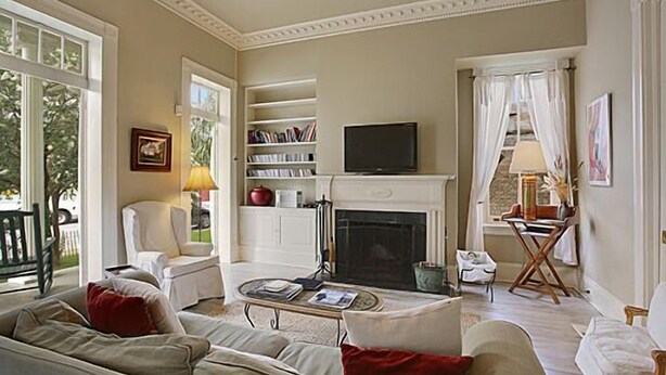 A spacious living room with a fireplace, a television, and a bookshelf.
