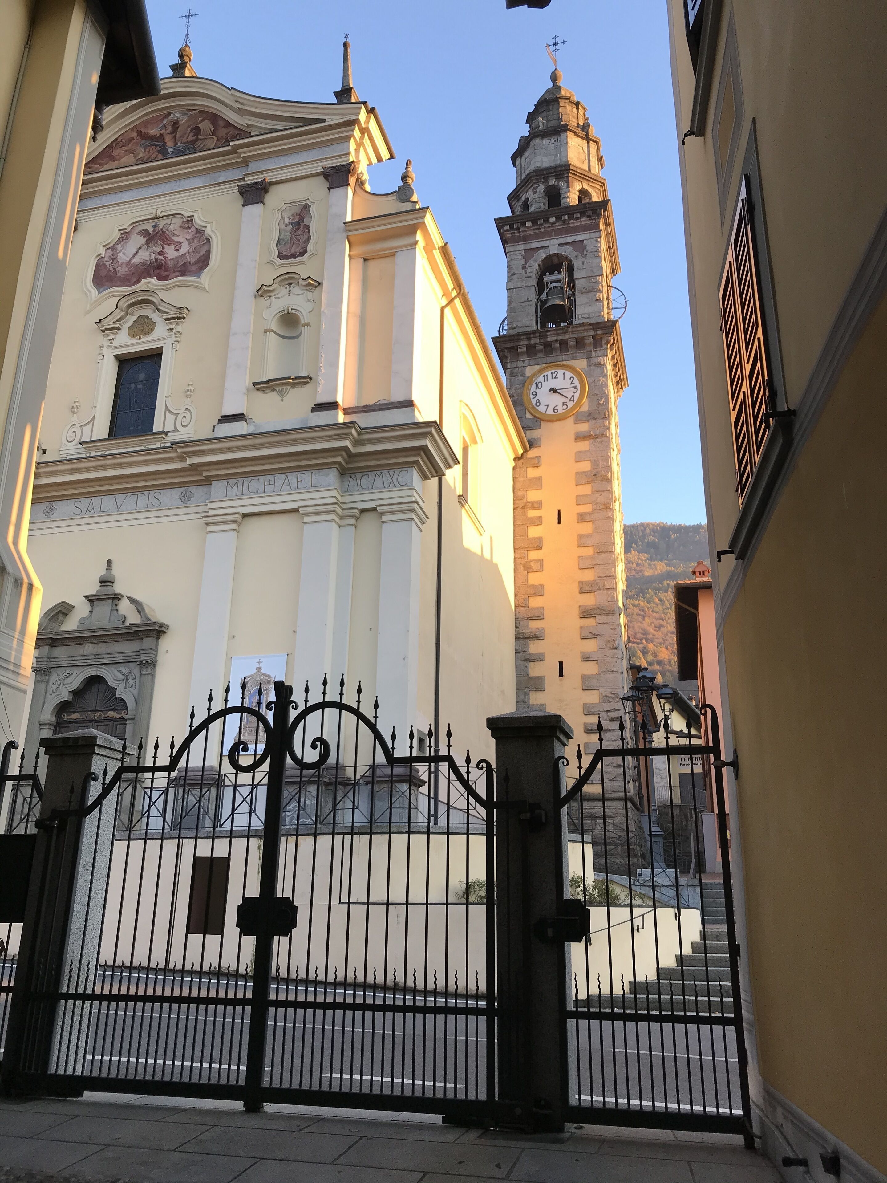 A building with a clock tower and a gate.