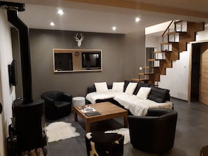 Relax in this stylish living room with a black leather sofa, wooden coffee table, and fireplace.