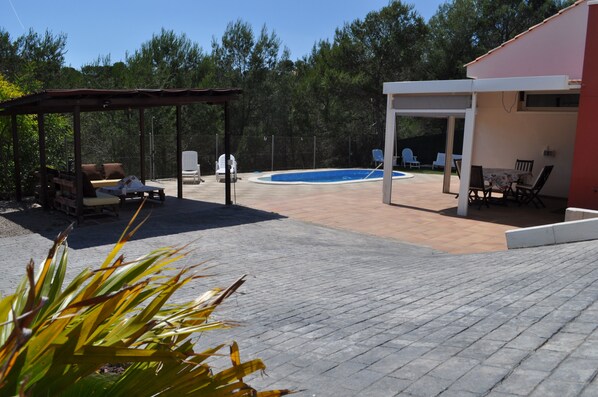 A backyard with a swimming pool, covered patio, and outdoor seating area. - House with pool, Garraf natural park and near Sitges beach FREE WIFI (olivella)