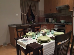 A dining area with a table set for four, including plates, glasses, and cutlery.