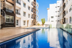 A residential building with a swimming pool, balconies, and a clear sky. - Loli Home Agadir - Houda Premium Pool (Agadir)
