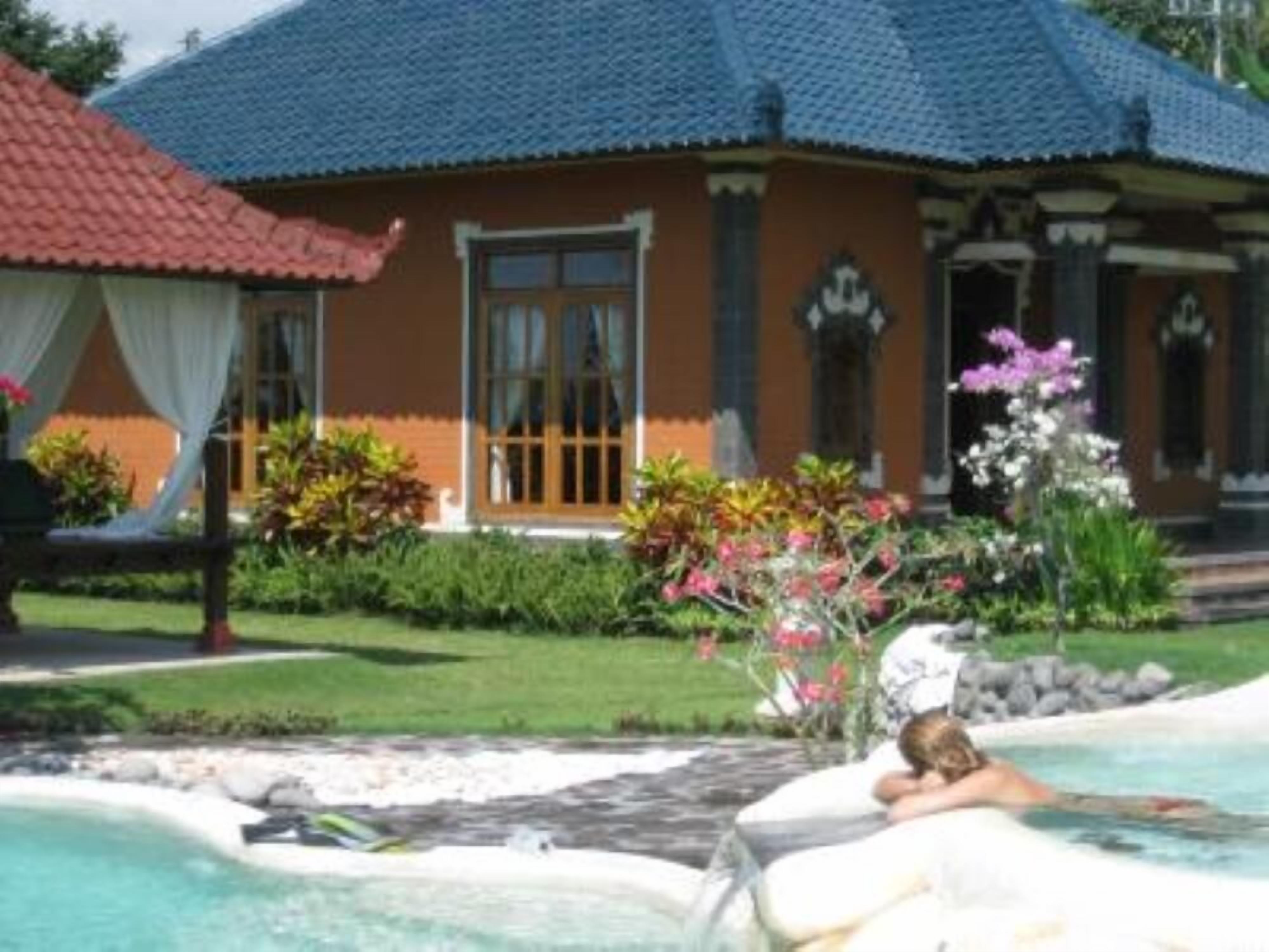 Una casa con tetto blu, piscina e giardino pieno di piante e fiori.