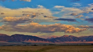 A mountainous landscape with a clear sky and scattered clouds. - McAllister Inn & Lodging (McAllister)