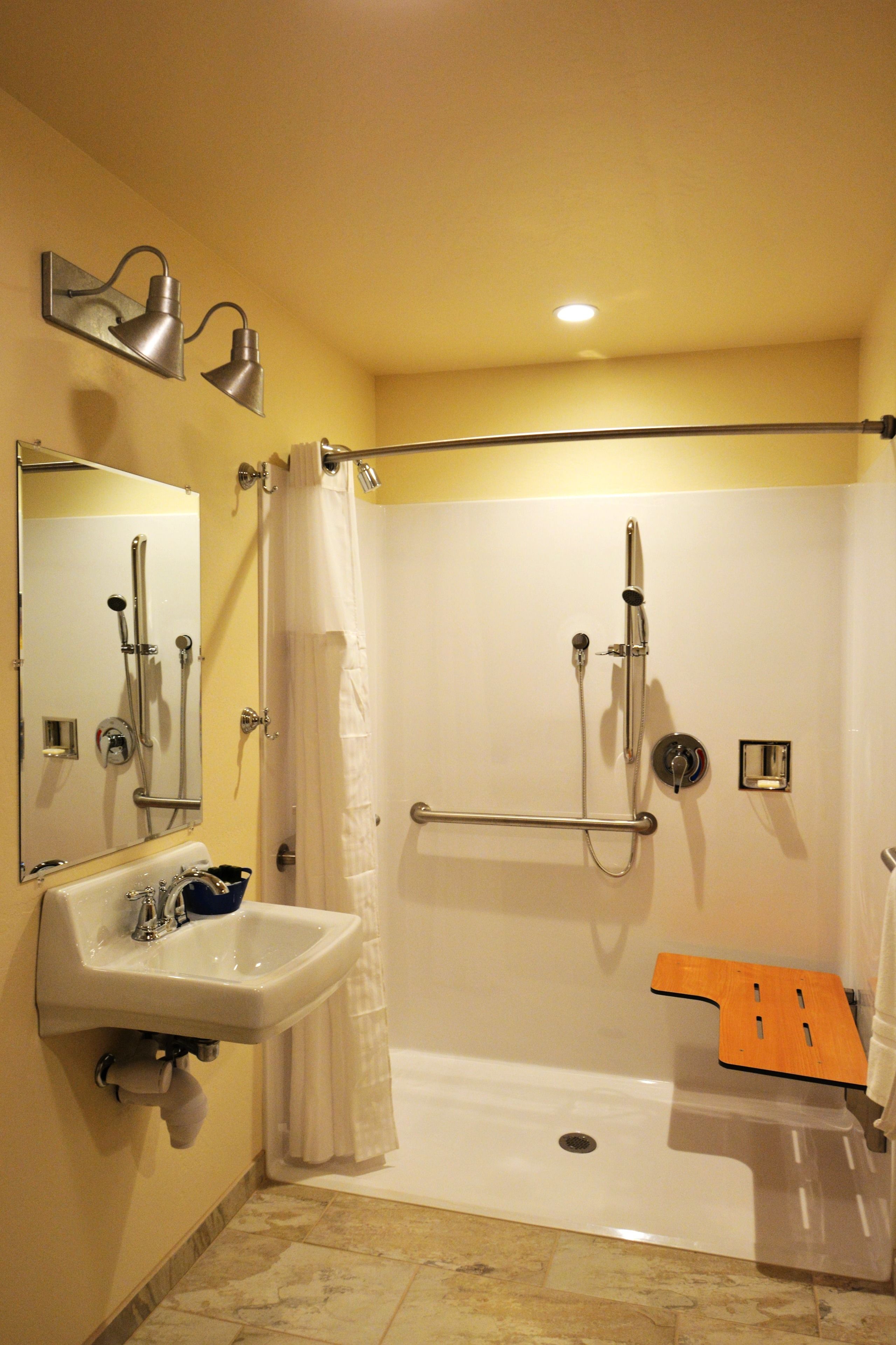 A modern bathroom with a shower, a sink, and a mirror.
