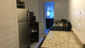 A kitchen with a refrigerator, microwave, stove, and a small sink. - River House Inn (Grassy Creek)