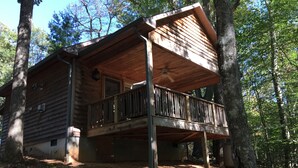 A cabin with a wooden deck, a balcony, and a covered porch area. - River House Inn (Grassy Creek)