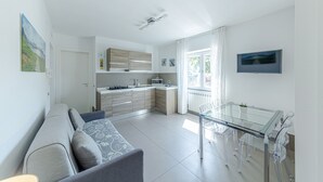Een moderne keuken met een eethoek, een bank en een televisie.