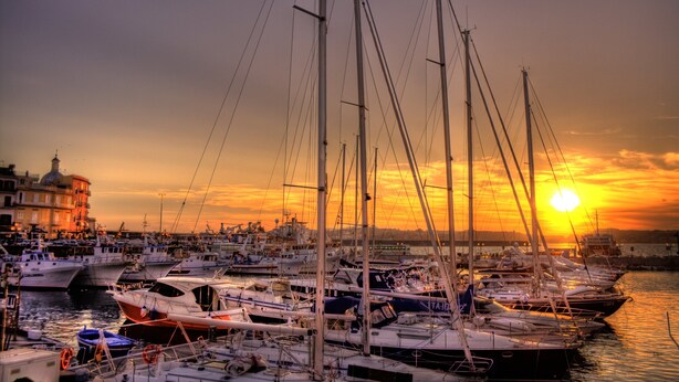 Een jachthaven met verschillende boten afgemeerd bij zonsondergang.