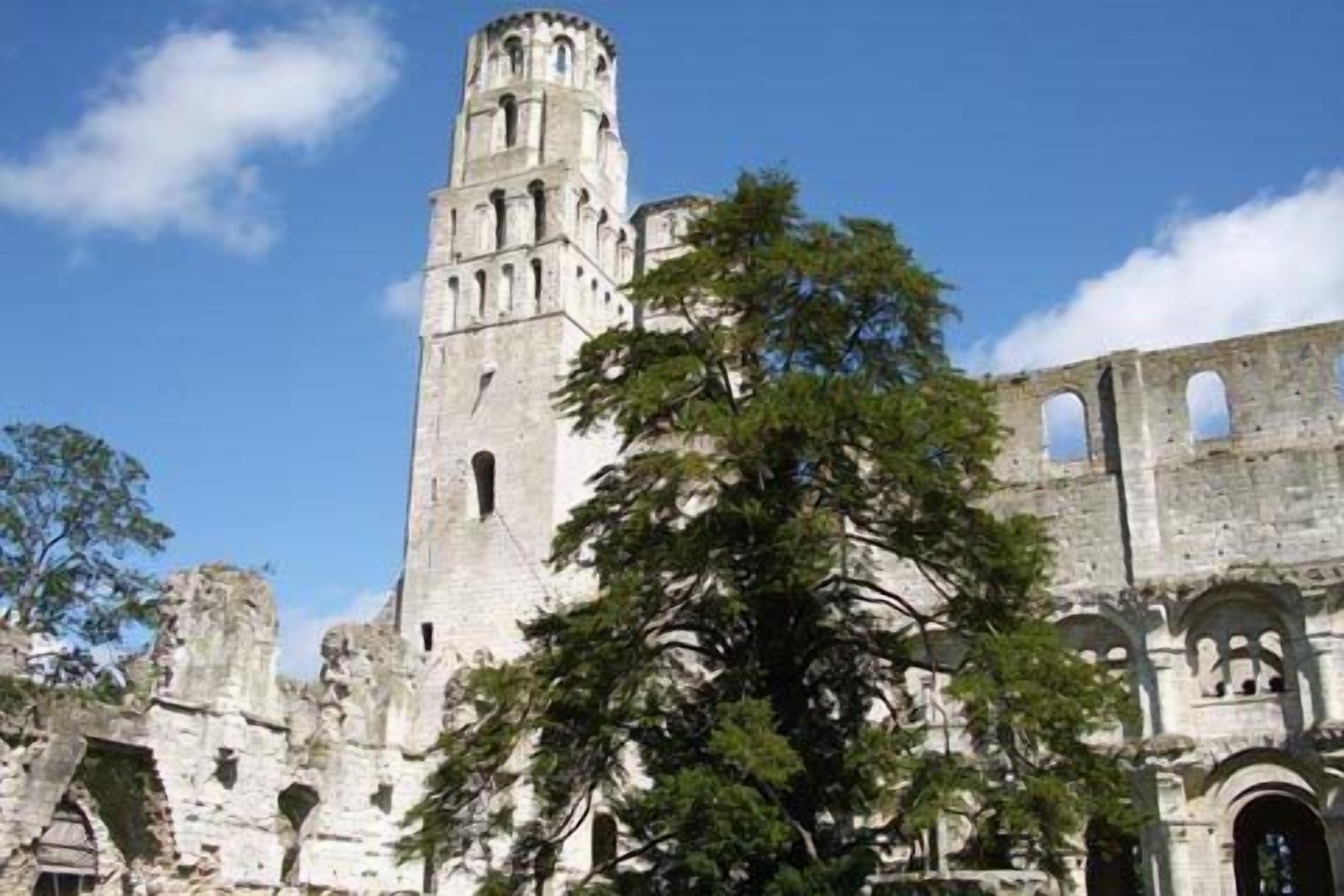 A historic stone building with a prominent tower and arched windows.