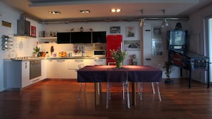 A modern kitchen with white cabinets, a red refrigerator, and a dining table with chairs. - design villa on the sea with a splendid view of the Gulf of Syracuse (Siracusa)