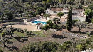 A villa with a swimming pool, surrounded by landscaped gardens and trees, set in a hilly landscape. - Rural villa with private outdoor pool, separate annexe and vast outdoor spaces (Gata De Gorgos)