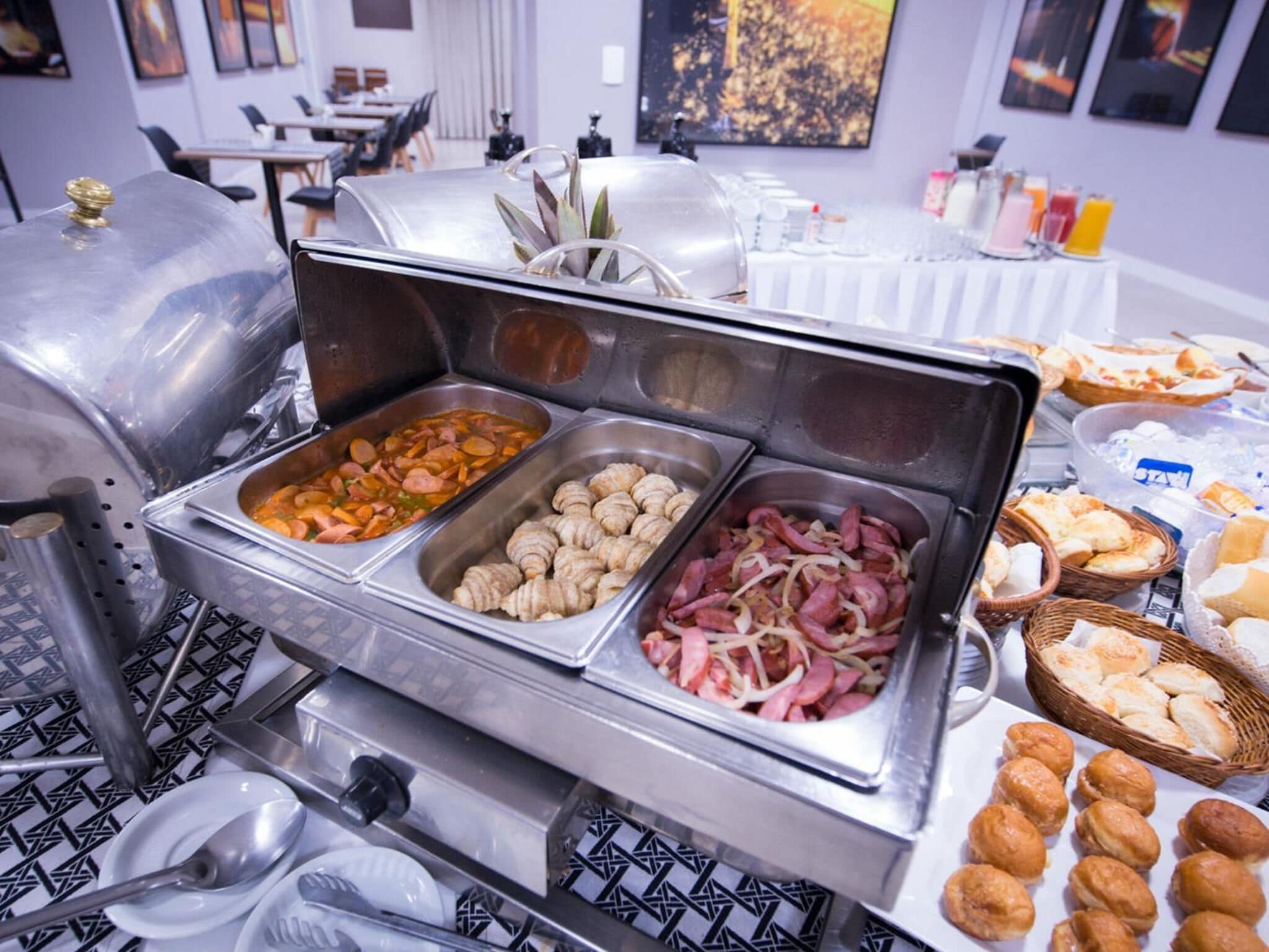Ein Buffet mit verschiedenen Speisen, darunter Würstchen, Gebäck und Brot.