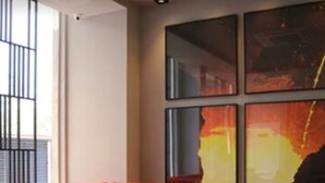 Una sala de estar moderna con un sofá rojo, sillas negras y una mesa de madera.