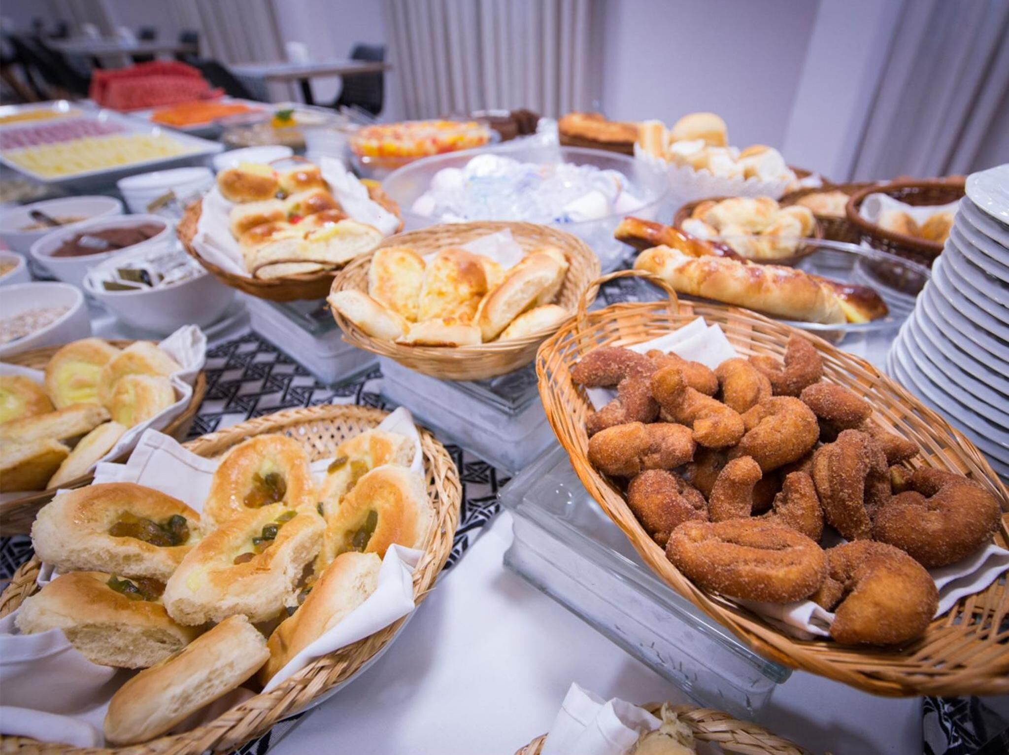 Un bufé con panes, bollería y salsas variadas.