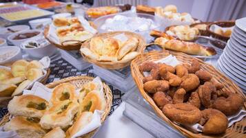 Un bufé con panes, bollería y salsas variadas.