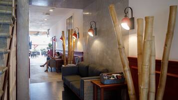 A modern interior with a sofa, bamboo decor, and wall-mounted lighting.