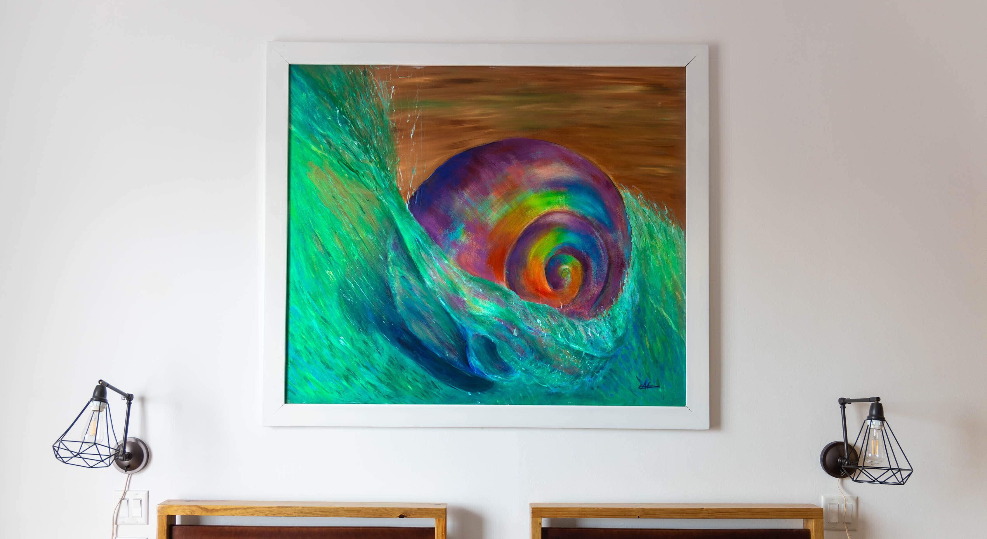 A vibrant abstract painting on a white wall, flanked by two geometric pendant lights.