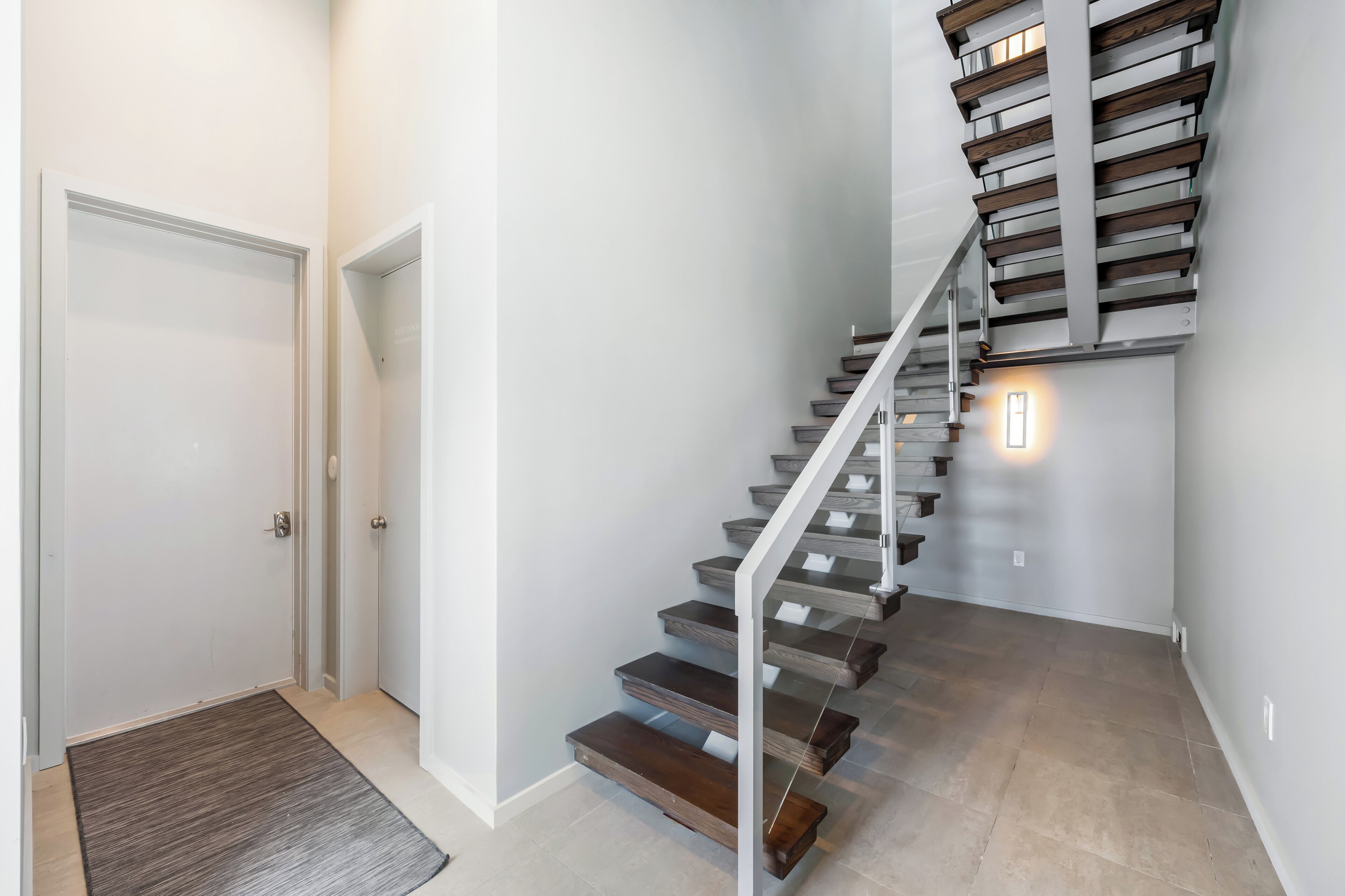 A staircase with wooden steps and metal railings, leading to an upper floor.