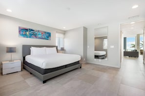 Un dormitorio moderno con una cama grande, mesitas de noche, un espejo y un cuadro abstracto y colorido en la pared.