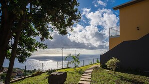 A pathway leading to a building with a view of the ocean. - Gorgeous, Modern Home with Breathtaking Views (Arco da Calheta)