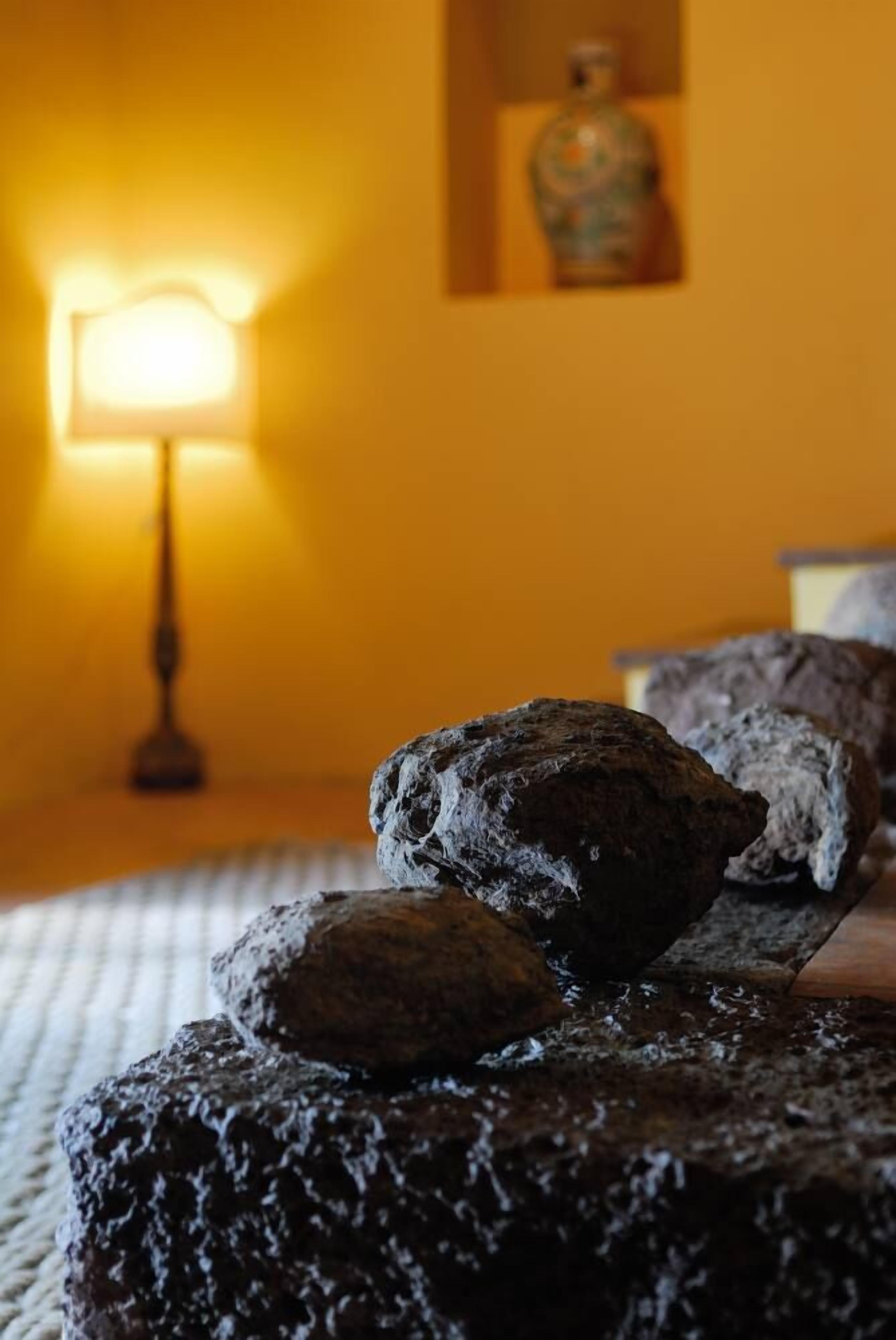 Een bed met een geribbelde deken en een lamp op de achtergrond.