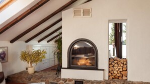 A cozy room with a stone fireplace, wooden beams, and a potted plant. - Fantastic apartment in Goslar am Harz (Goslar-Jerstedt)