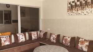 Una sala de estar moderna con un banco empotrado, un ventanal con cortinas y una obra de arte colgada en la pared.