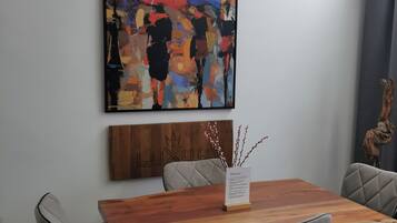 A conference room with a wooden table, grey upholstered chairs, and a colorful abstract painting on the wall.