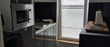 A compact kitchen with a microwave, a refrigerator, and a small countertop.