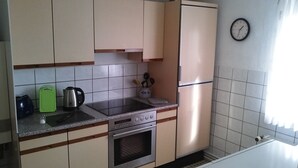 Une cuisine de taille réduite équipée d’une cuisinière, d’un four, d’un évier et d’un réfrigérateur.