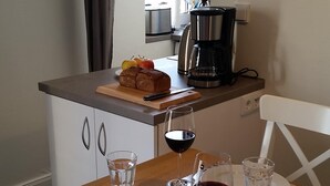 A dining table set with plates, glasses, and a loaf of bread. - Newly renovated, close to the beach, sunny, south-facing balcony, WLAN (Sylt /Westerland)