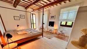 Une chambre confortable avec un lit, un bureau, une chaise et une fenêtre avec des rideaux.