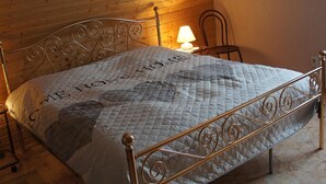 A bed in a room with wooden ceiling and walls, a metal headboard, and a single bedside lamp. - Large apartment (92 sqm) "sea eagle" 1-6 people in a great location (Kargow)