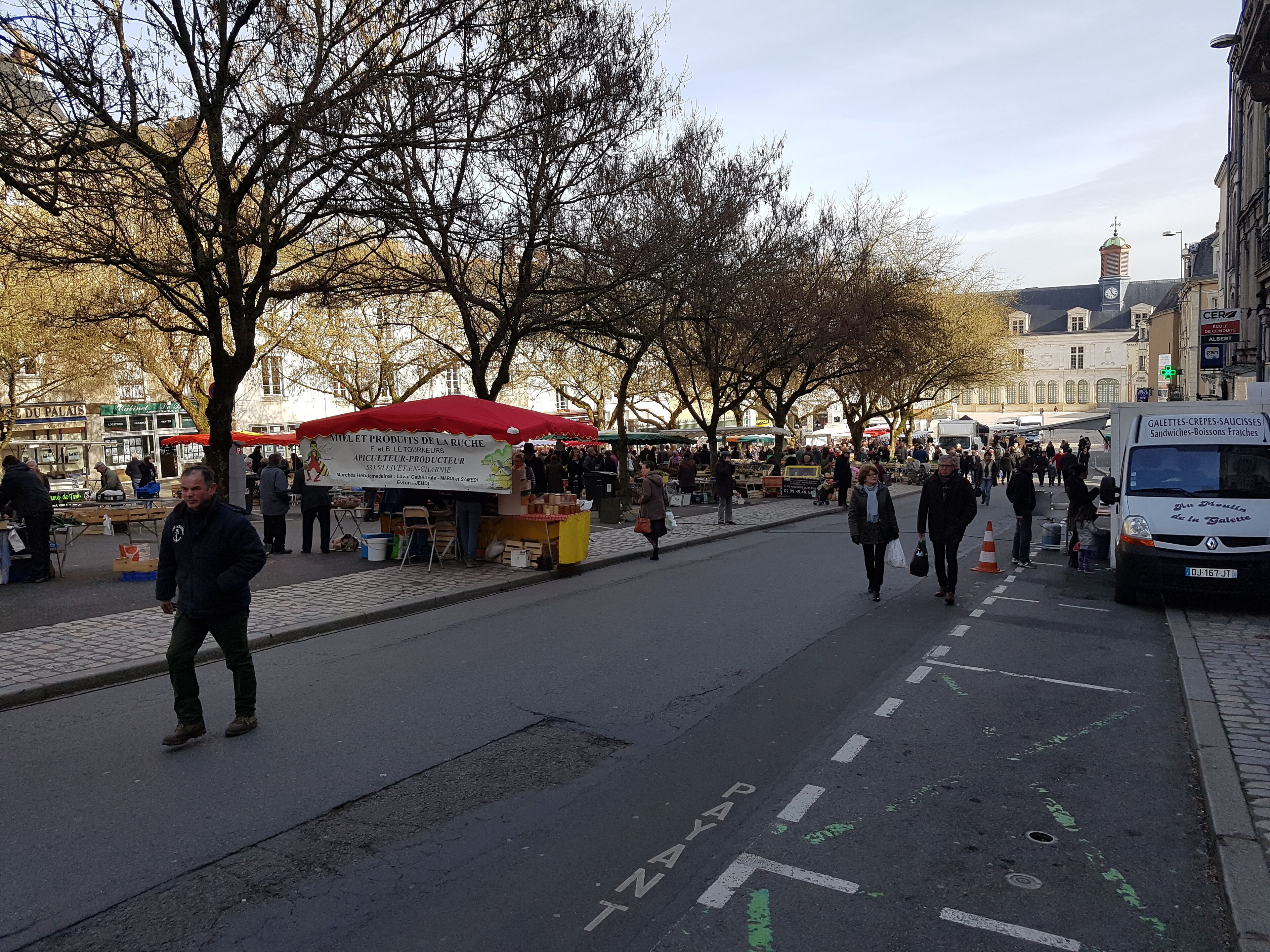 Un marché de rue avec des étals et des passants.
