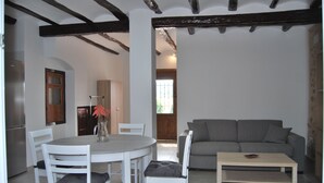 Un comedor con una mesa redonda y sillas, un sofá gris y una mesa de centro de madera.