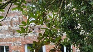 Un bâtiment en briques avec des fenêtres à cadre blanc et un mur en pierre.