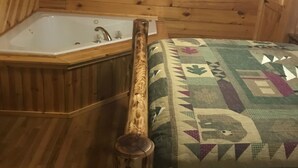 Ein Holzblockhaus-Interieur mit einer Holzwanne, einer gesteppten Bank und einer Holzsäule.