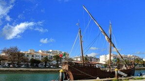 Ein historisches Schiff liegt im Hafen vor einer Gebäudebäckgrund.