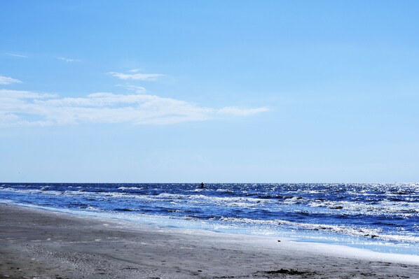 Una playa con olas y cielo despejado.