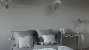 Un dormitorio con cama, mesitas de noche y lámparas de pared.